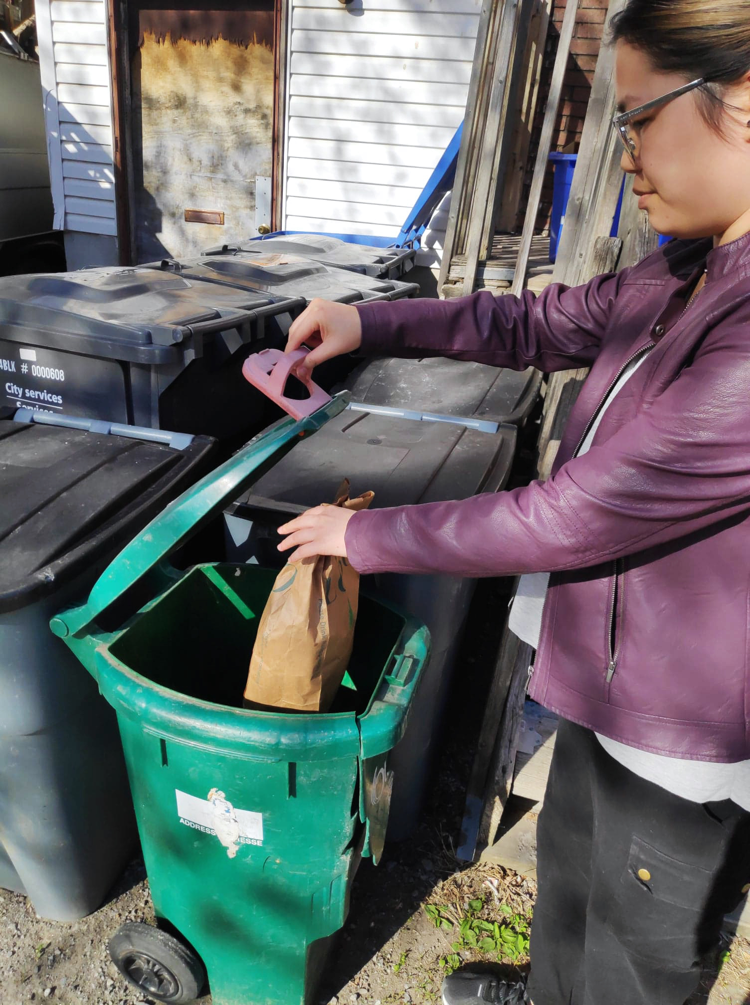Ocean Bridge youth ambassador Celina Feng from Ottawa, Ontario puts an item into her green bin to compost.
