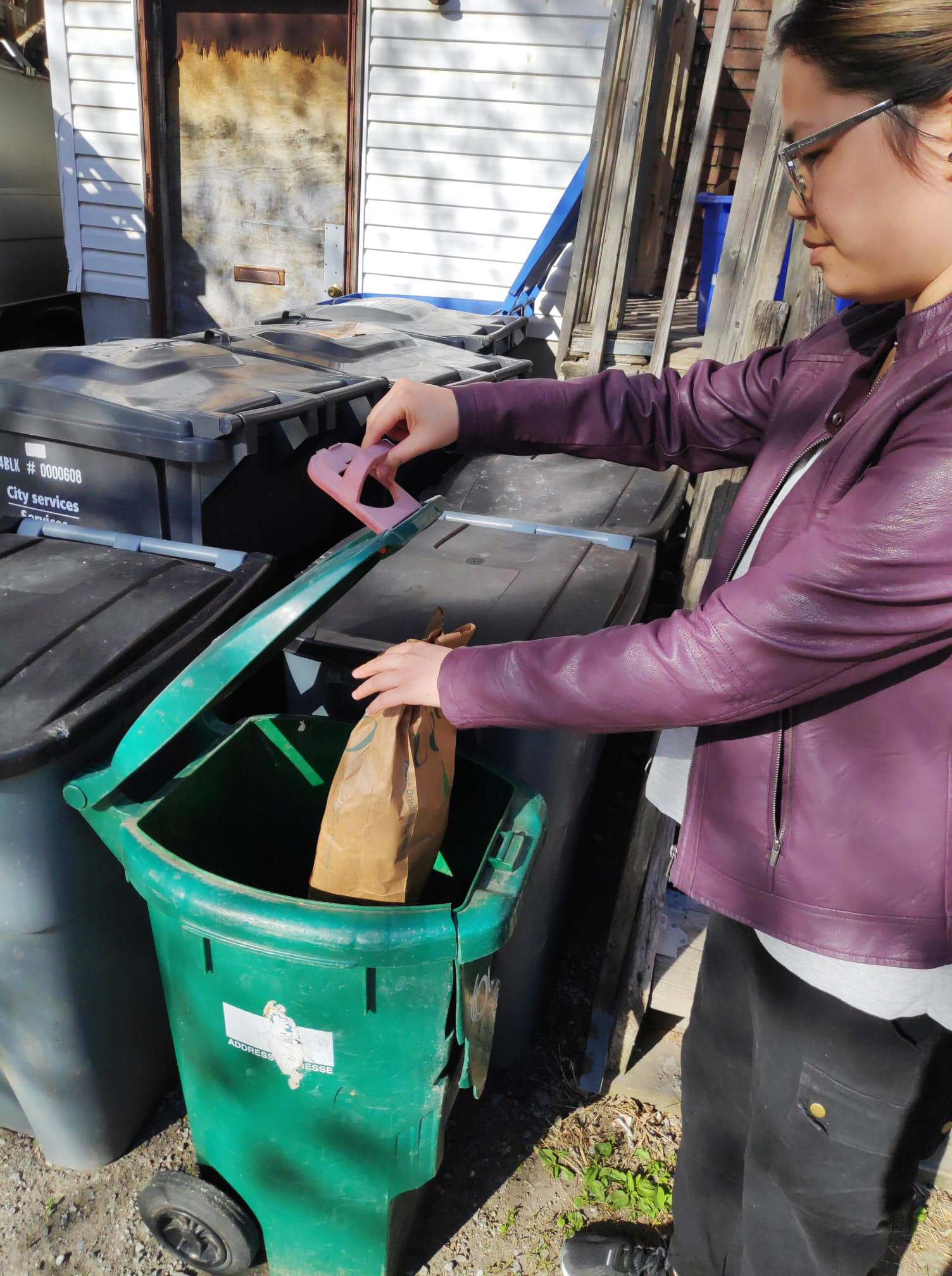 Portail Océan jeune Ambassadeur(rice) Celina Feng d'Ottawa (Ontario) met un article dans son bac vert pour le composter.