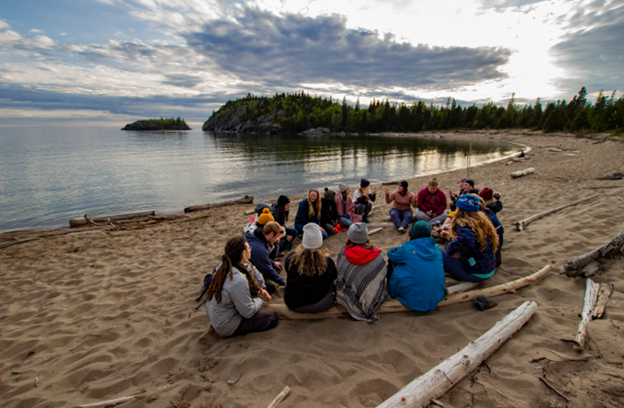 participant(e)s de Portail Océan de la Cohorte 2019 des Grands Lacs assis en cercle sur une plage du lac Supérieur.